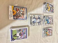 Stacks of sleeved football trading cards including Panini Prizm insert on top