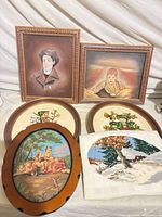 Lot overview showing two paintings and needlework pieces