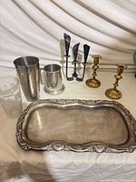 Group shot of all seven items: tray, candlesticks, candelabra, shaker, tankard, printed glass