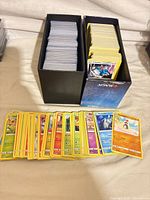 Two storage boxes filled with Pokémon cards, additional cards displayed in front