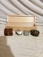 Full view of all six boxes closed in front of open cigar box