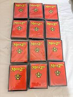 Front view of multiple sealed MetaZoo sleeve packs showing red packaging and logos