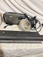 Group view of radio, monolight with reflector, LED light bar and cables