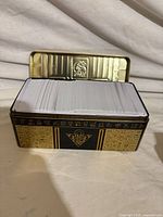 Stack of cards inside black and gold Yu-Gi-Oh tin with lid open