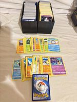 Two-row storage box filled with Pokémon cards and sample cards displayed in front