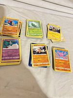 Five stacks of Pokémon cards sorted face-up showing mix of commons/uncommons