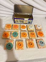 All 14 boxed plastic parts arranged with metal tin