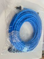 Coiled blue extension cord in clear packaging showing male plug