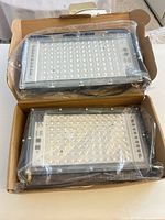 Two LED flood lights in box with plastic wrap