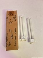 Two CFL bulbs and box showing wattage, base type and colour temperature