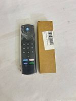 Front view of new Alexa voice remote beside cardboard box