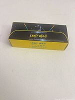 Front view of yellow and black box labeled LIGHT BULB