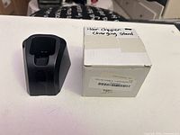Front view of black charging stand beside box