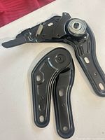 both hinge mechanisms front view showing lever, spring and mounting holes