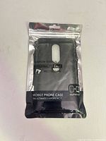 Front of sealed pouch showing black TPU phone case with camera cut-out