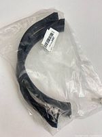 Sealed bag containing curved black trim molding pieces with barcode label