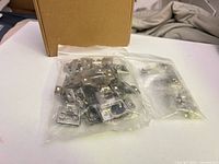 Sealed bags of cabinet hinge mounting clip plates and screws