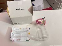Bottle, cap with metal tube, box, instructions displayed