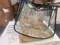 clear PVC organizer bag displayed upright with hardware and instructions visible