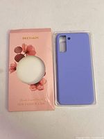 Front of purple phone case beside front of floral Deenakin box