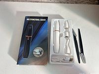 Box front and tray with trimmer, three heads, cable, razor