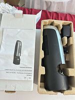 Air purifier in molded insert beside manual and box