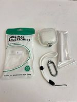 Front view showing silicone case, carabiner, lanyard strap, sealed accessory, and retail pouch