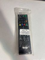 Front view of sealed black RMT-B107A remote showing full keypad and label