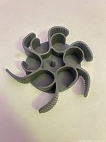 Top view showing circular silicone accessory with six inner loops and ribbed arms