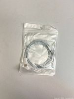 Front view of sealed package containing coiled white Lightning to 3.5 mm audio cable
