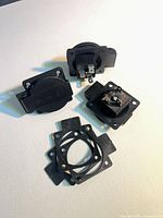 three plastic joystick mounting housings and four rubber gaskets arranged on surface