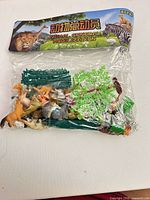 Front view of sealed bag showing assorted animal figures and accessory pieces