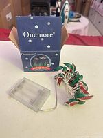 Onemore box front, clear battery pack, coiled watermelon string lights visible