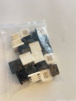 Sealed bag showing mixed black and white square plastic inserts