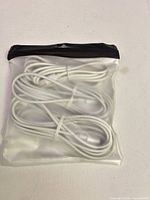 Front of sealed pouch showing three coiled white cables