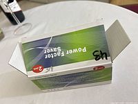 Top view of opened Power Factor Saver retail box showing exterior graphics and handwritten mark