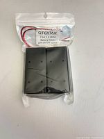 Front of sealed package showing QTEATAK label, wiring and battery holder