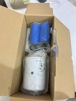 Box containing white filter cartridge 51736 and two blue capacitors still in plastic