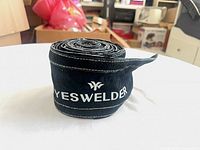 Front view of rolled canvas strip showing YesWelder logo and stitching