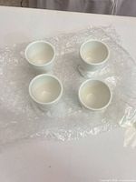 Four white egg cups on bubble wrap