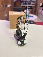 Front view of Jiji cat lamp with boxed background
