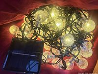 String lights illuminated showing warm white glow with solar panel visible