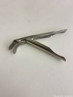Side view of stainless steel vaginal speculum, blades closed