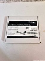 Front view of sealed StarTech adapter box showing model and specifications