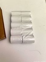 Ten white thermal paper rolls banded together
