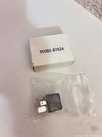 Relay in plastic bag beside box showing part number