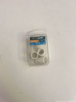 Front of sealed TruGuard blister pack showing 4 white vinyl chair leg caps