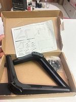 Box showing one TV leg, screw bag, instruction sheet