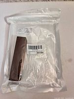 Factory-sealed acrylic sign and brown base block visible inside packaging