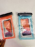 Front view of both sealed waterproof phone pouches, orange and teal